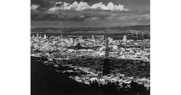 A black-and-white photograph of an arial view of San Francisco, parts of which are in shadow from clouds.