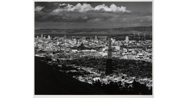 A black-and-white photograph of an arial view of San Francisco, parts of which are in shadow from clouds.