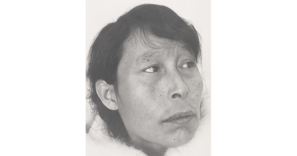 A black-and-white photograph of a close-up of an Indigenous woman with short dark hair and some freckles.