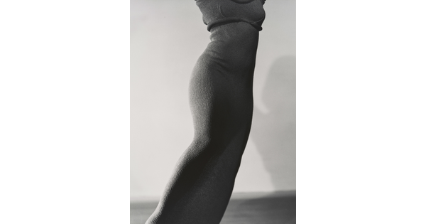 A black-and-white photograph of a slim, feminine torso wearing a form-fitting, knit dress.