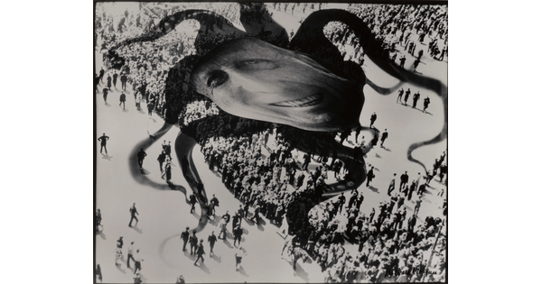 A black-and-white photograph of a distorted face superimposed over the shadow of an octopus hovering above a crowd of people.