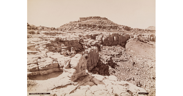 A black-and-white photograph of a rocky landscape and a dry gully.