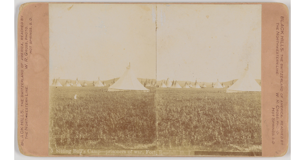 A sepia-toned stereograph of multiple tipis on a grassy field.