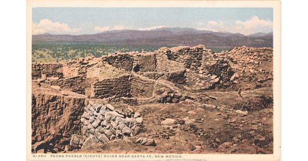 A color postcard of a ruined, stone building with multiple rooms in a mountainous landscape.