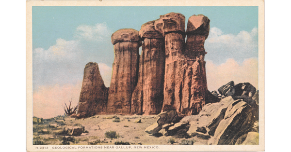 A color postcard of a tall rock formation in a desert landscape.