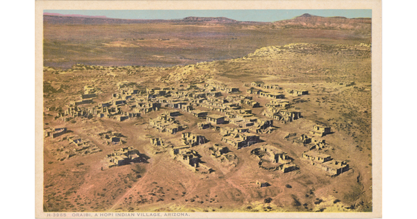 A color postcard of a bird's eye view of a small village in a dusty orange desert landscape.