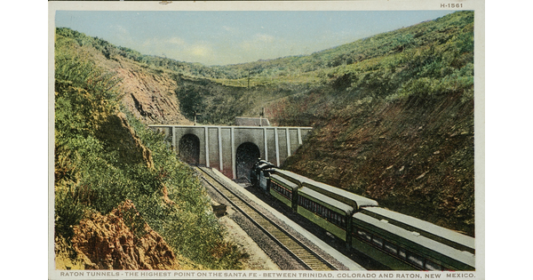 A color postcard of a train entering a tunnel in a green mountainside.