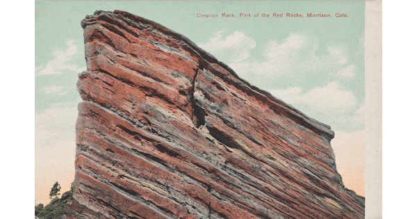 A color postcard of a tall, red rock formation jutting into the sky.
