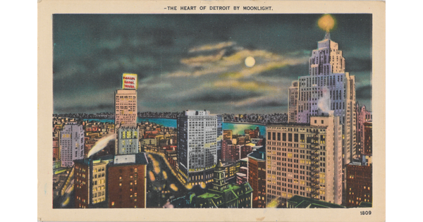 A color photograph postcard of a riverside city at night, buildings lit up, and the moon shining through dark clouds.