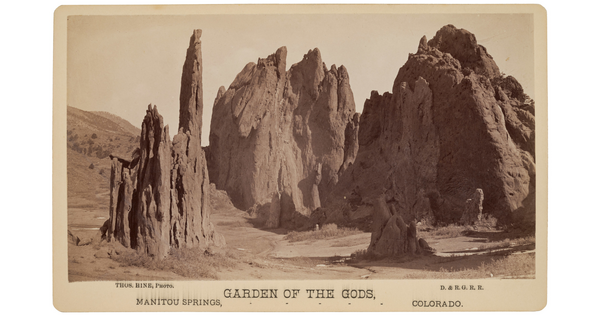 A sepia-toned photograph of large rock formations in a barren landscape.