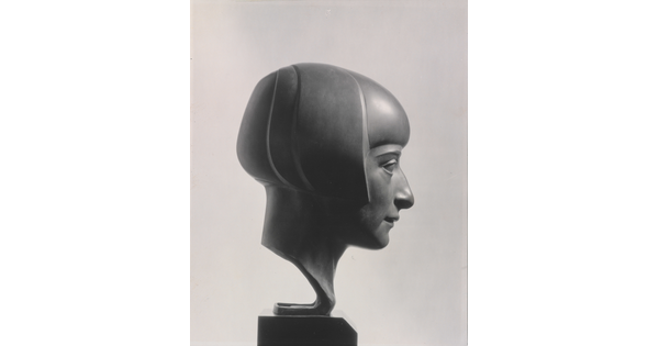 A black-and-white photograph of a bronze bust of a woman in profile with a bobbed haircut.