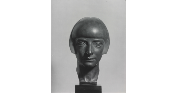 A black-and-white photograph of a bronze bust of a woman with a bobbed haircut from the front.