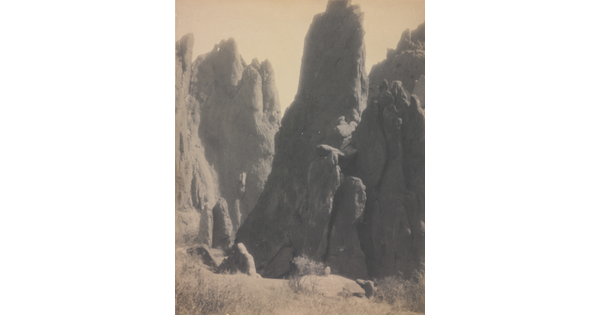 A black-and-white photograph of large hoodoos, or vertical spires of rock.