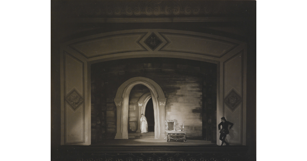 A black-and-white photograph of a woman and man performing on a stage.