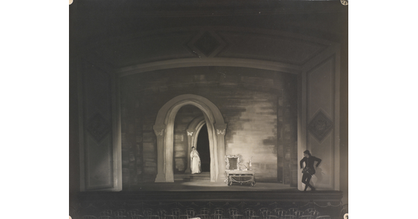 A black-and-white photograph of a woman and man performing on a stage.