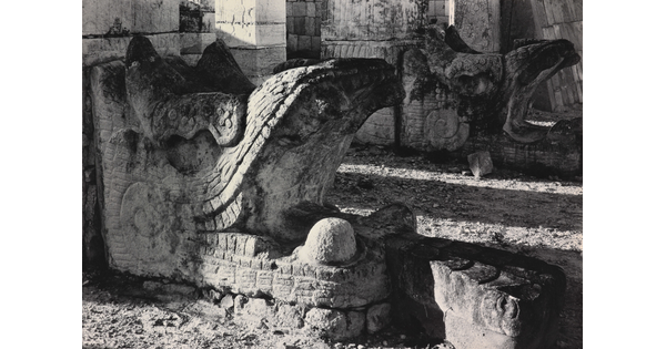 A black-and-white photograph of an ancient stone architectural embellishment in the form of an open-mouthed beast.