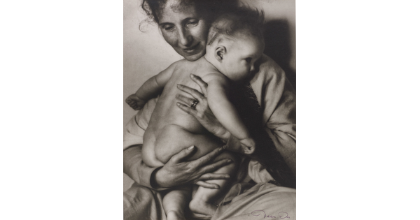A black-and-white photograph of a White woman holding a naked baby to her chest.