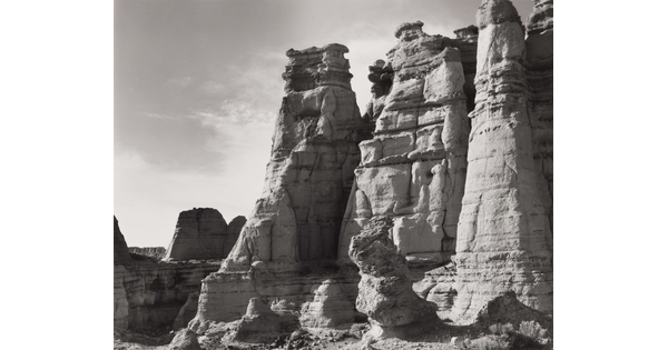 A black-and-white photograph of large rock formations.