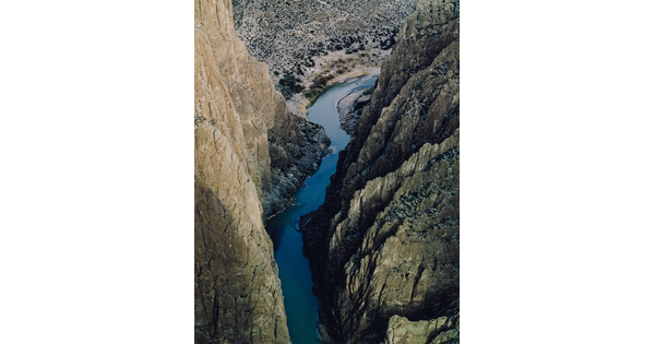 A color photograph taken from above of a river running through a narrow and steep canyon.