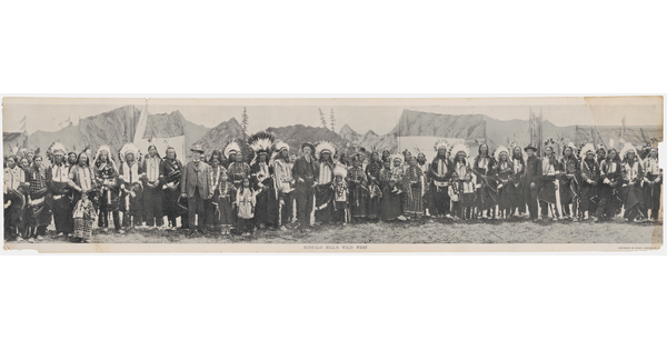 A black-and-white panoramic photograph of a large group of people, some in western-style clothing and others in Native American dress.