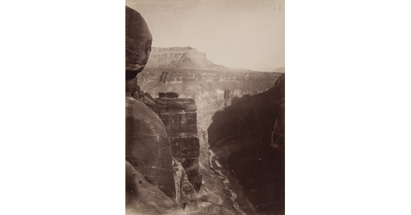 A black-and-white photograph, taken from high up, overlooking a winding river surrounded by cliffs.