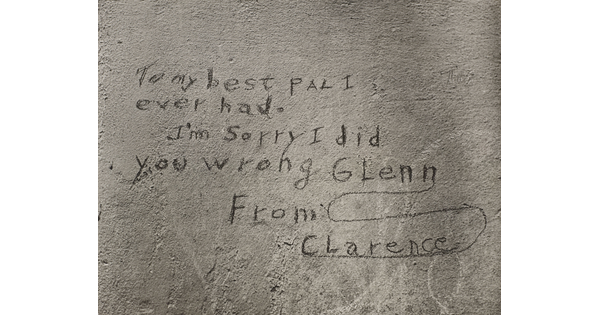 A black-and-white photograph of a note written on what looks like a cement wall that reads: "To my best pal I ever had. I'm sorry I did you wrong Glenn. From Clarence."