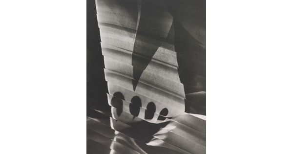 An abstract black-and-white photograph of a skewed white rectangular shape broken by a dark triangle, four tear-drop shapes, and lines.