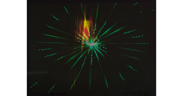 An abstract color photograph of a bright green starburst with a rectangle of orange and yellow light on a black background.