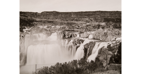 A black-and-white photograph of waterfalls tumbling down a rock face.