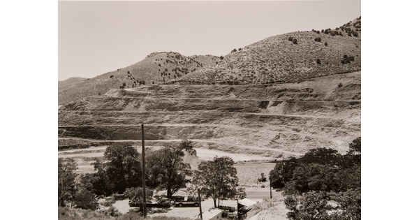 A black-and-white photograph of a mountainside that has been strip mined and the town below.