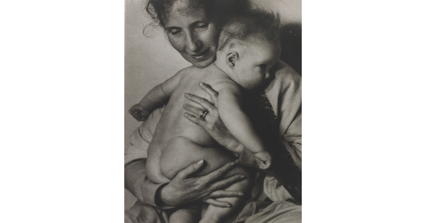 A black-and-white photograph of a White woman holding a naked baby to her chest.