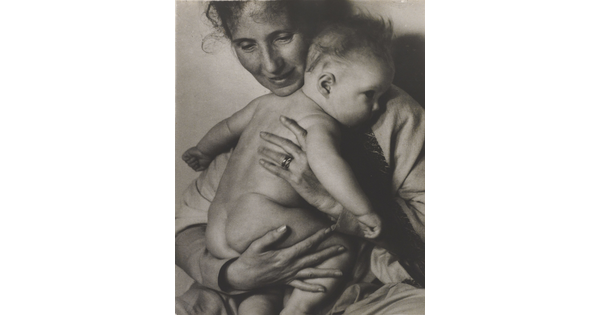 A black-and-white photograph of a White woman holding a naked baby to her chest.