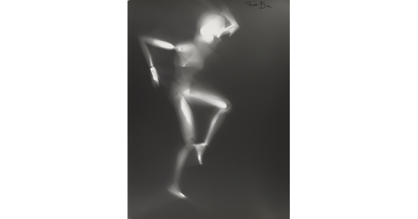 A black-and-white photograph of a white person-shaped puppet dancing on a black background.