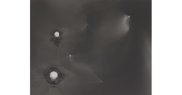 An abstract black-and-white photograph of foggy star-like constellations against a black background.