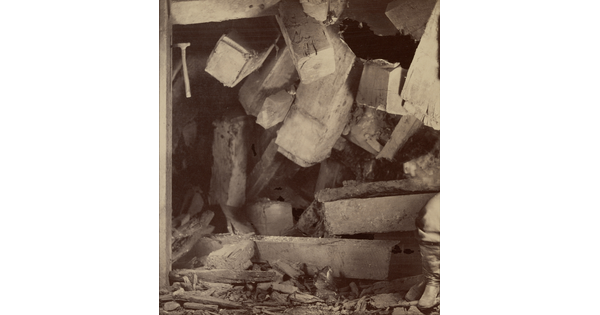 A sepia-toned photograph of fallen wood and debris blocking what was previously the opening of a mine.