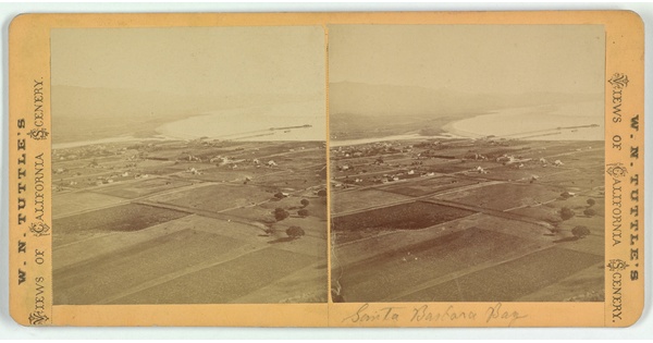 Two almost identical side-by-side sepia-toned photographs of flat land dotted with buildings next to a body of water.