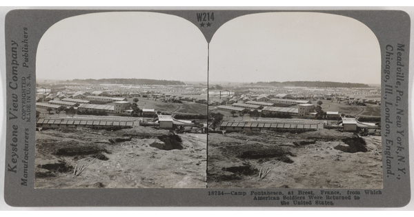 Two almost identical side-by-side black-and-white photographs of a mostly flat landscape with a few trees and long, flat industrial buildings.