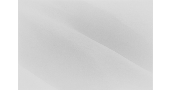 A black-and-white landscape photograph of snow covered hills.