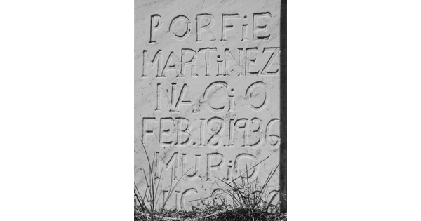 A close-up, black-and-white photograph of inscribed text on a marble gravestone.