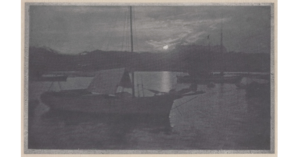 A black-and-white photograph of sailboats with lowered sails in a calm body of water, with a low sun peeking through the clouds near the horizon.