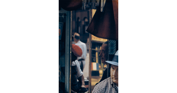 A color photograph of a four men at various angles captured in window reflections.