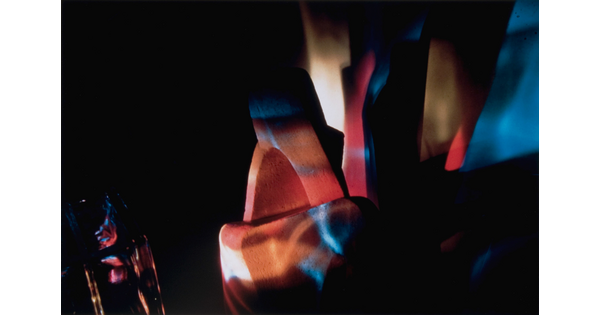 An abstract color photograph of blue, red, and orange light illuminating unknown objects.