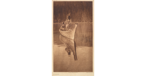 A sepia-toned photograph of two Indigenous people in a canoe floating on calm water.
