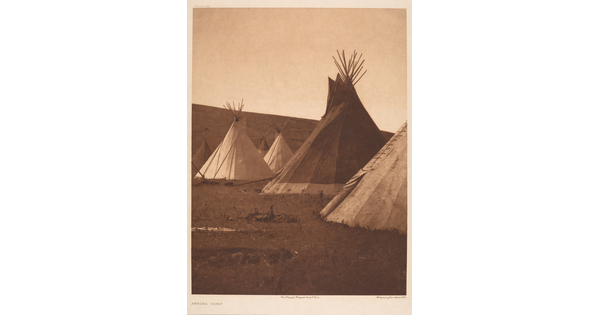A sepia-toned photograph of a tipi camp.