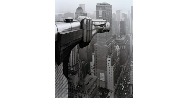 A black-and-white photograph of an Art-Deco gargoyle of an eagle overlooking the New York cityscape.