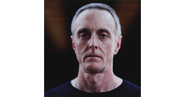 A color photograph of the head and shoulders of a White man with short gray hair and a serious facial expression.