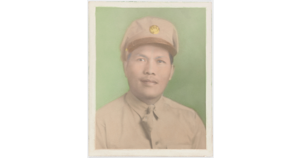 A faded color photograph of a man with Asian features wearing a khaki military hat and uniform against a green background.