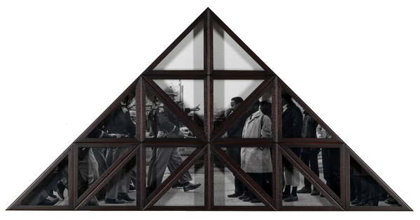 A triangular wood frame divided into smaller triangles over a black-and-white photograph of a group of Black people being confronted by White police officers.